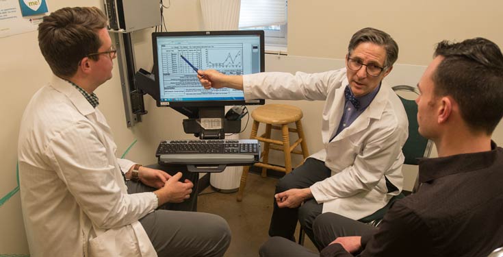 Two men in white coats showing patient test results